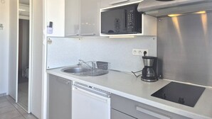A modern kitchen with a built-in dishwasher, a coffee maker, and a microwave. - Comfortable studio with air conditioning - Cap d'Agde (Cap d'Agde)