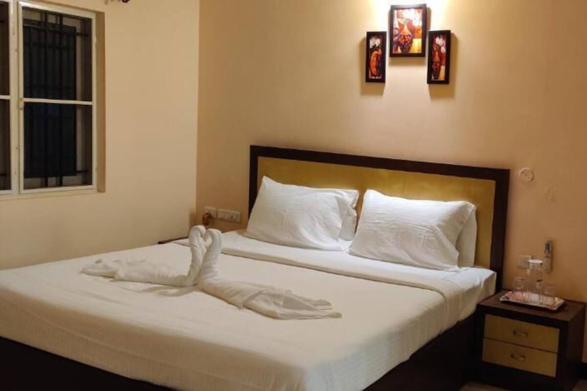 Una habitación de hotel con una cama, una mesita de noche y un cuadro colgado en la pared.