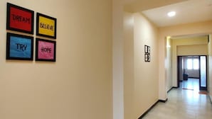 A hallway with framed inspirational words on the wall and a door at the end.