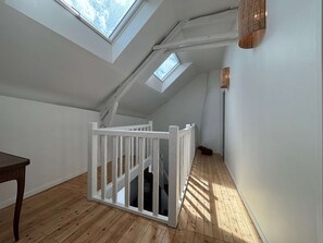 A room with skylights, wooden flooring, a white railing, and a lamp. - Ideal house in peaceful location - 6 guests (Guérande)