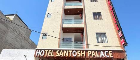 A multi-story building with a sign reading 'HOTEL SANTOSH PALACE.'