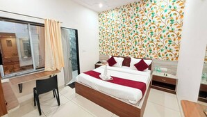 Una habitación de hotel moderna con una cama, un escritorio, una silla y una ventana con cortinas.
