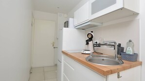 A small kitchenette with a sink, a microwave, a toaster, and a bottle of dish soap. - Studio 150m from the beach - 2 guests (Le Grau-du-Roi)