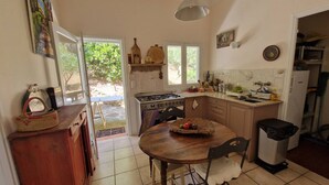 Una cocina compacta con una mesa de comedor, una estufa y un lavabo.