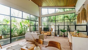Un salón amplio con ventanas grandes, techo de madera y diseño moderno.