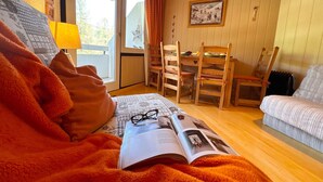 Tunnelmallinen huone, jossa on sänky, pöytä tuoleineen, ikkuna ja seinällä oleva kehystetty kuva.