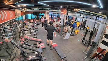 A gym with treadmills, weight machines, and benches.