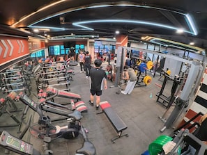 A gym with treadmills, weight machines, and benches. - Penthouse 6500 Hotel (Tacloban)
