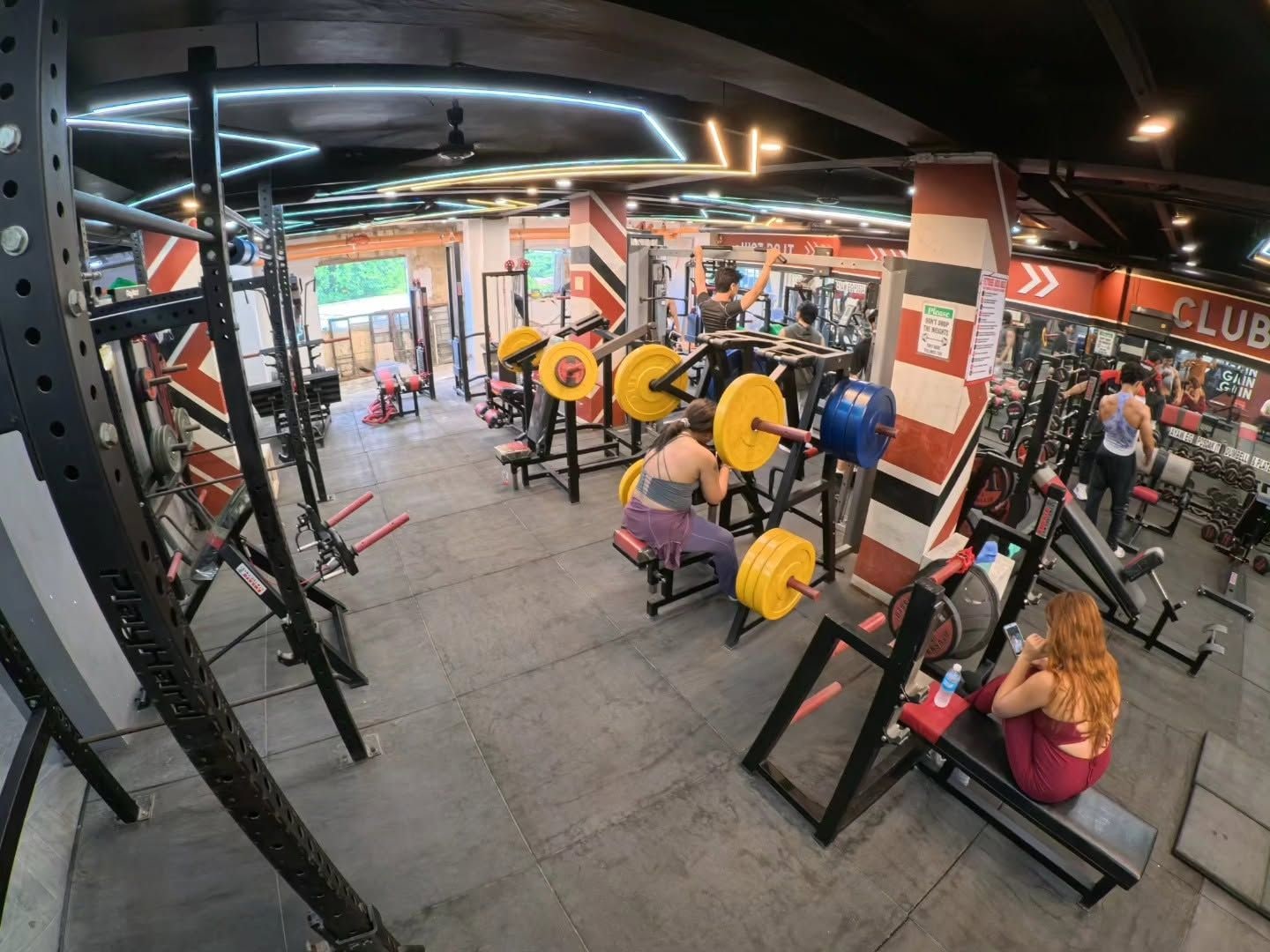 Ein Fitnessraum mit verschiedenen Trainingsgeräten, darunter Kraftmaschinen und Kurzhanteln.