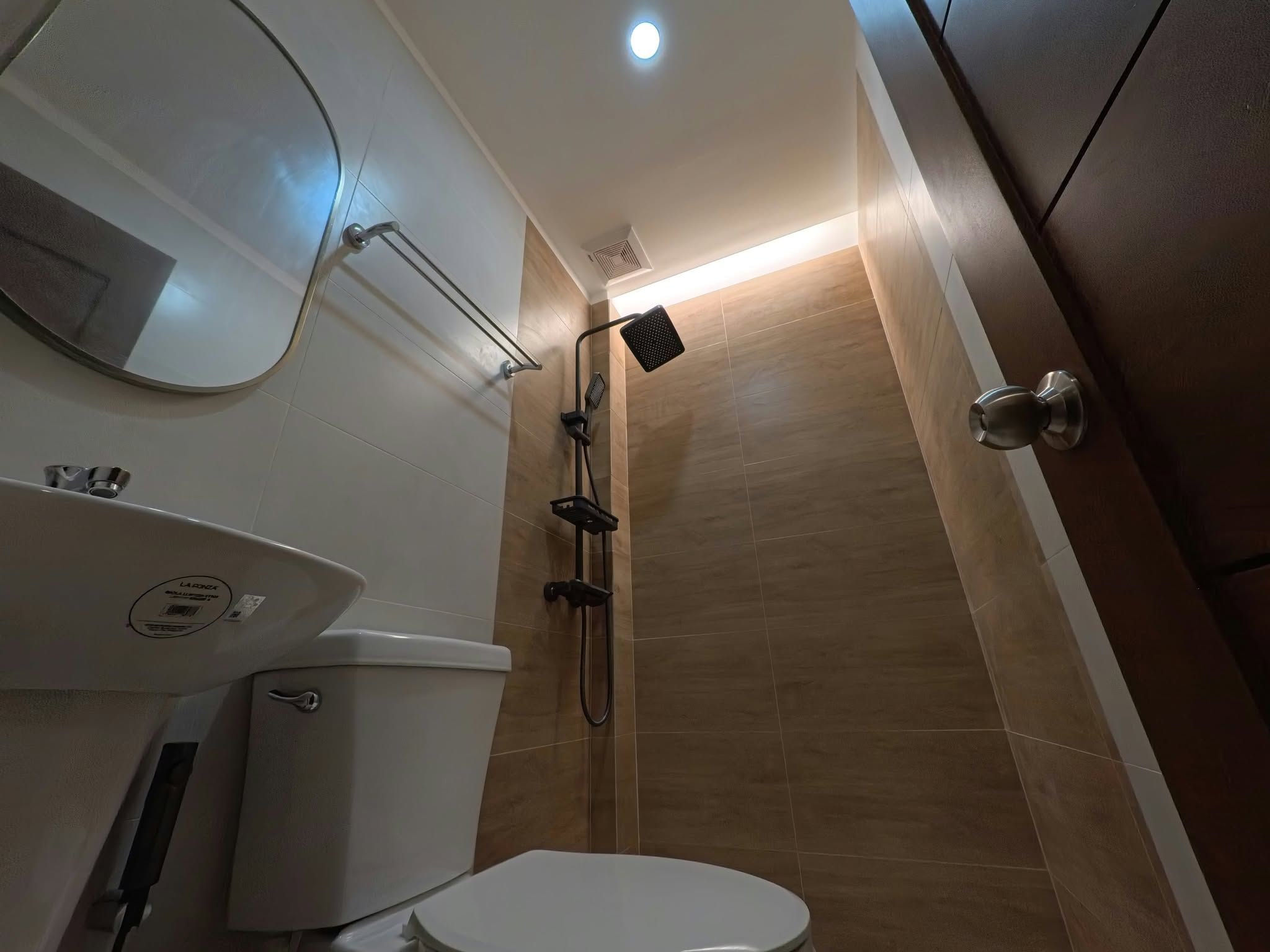 Een badkamer met toilet, wastafel en douche.