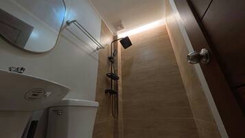 A bathroom with a toilet, sink, and shower.