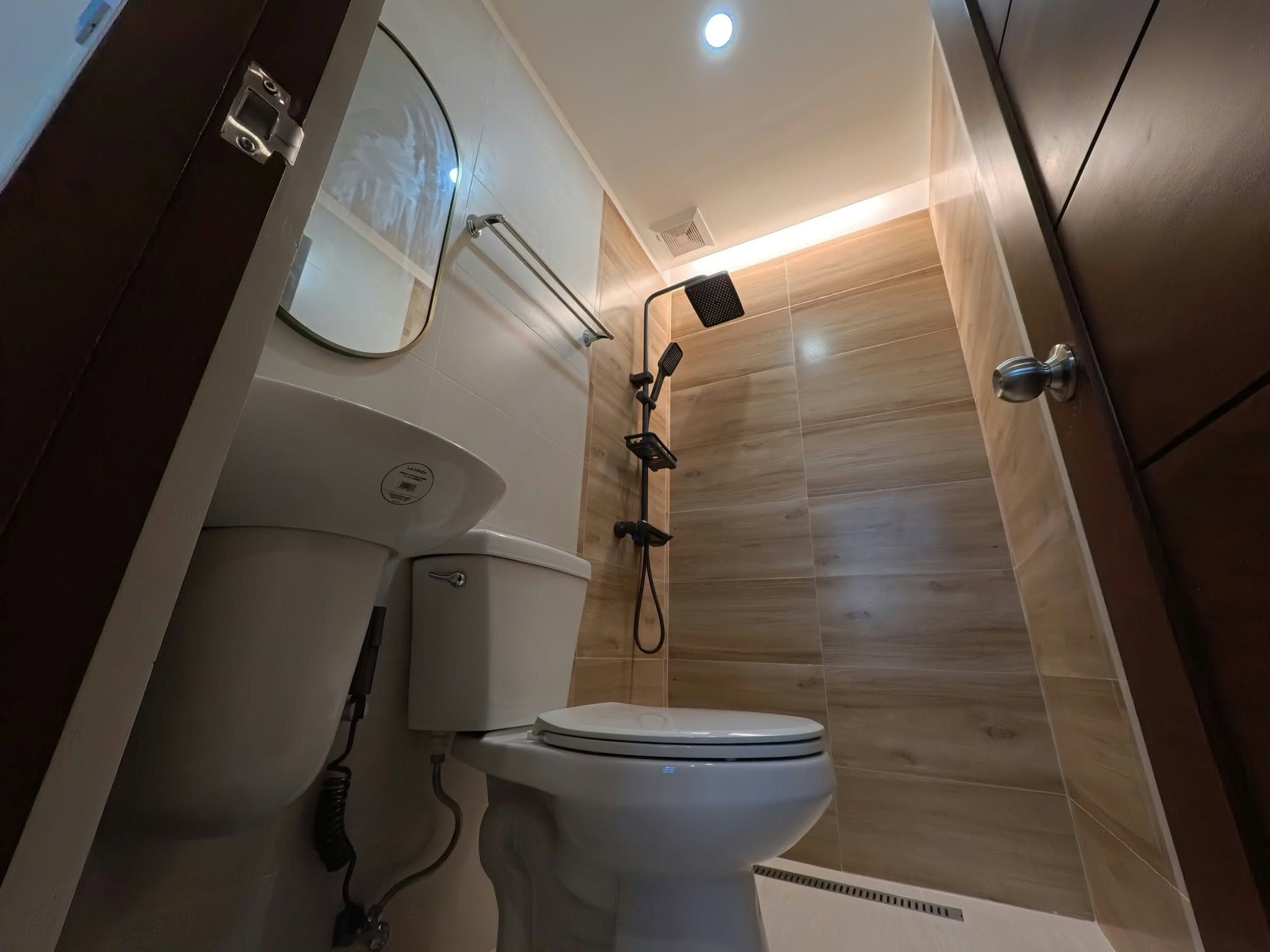 Un baño con inodoro, ducha y espejo.