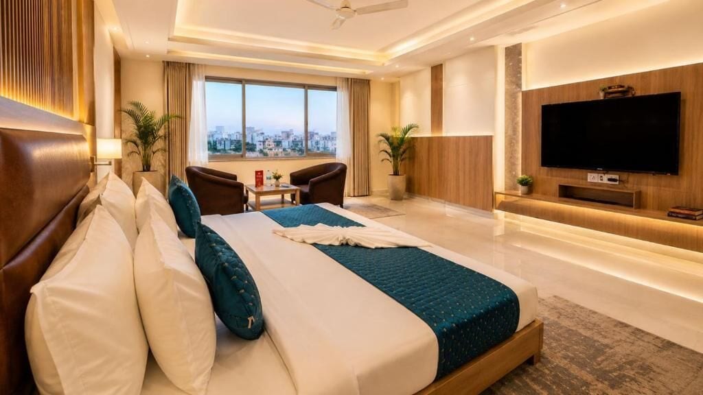 Une chambre d’hôtel moderne dotée d’un grand lit, d’une télévision, d’un bureau et offrant une vue sur la ville.