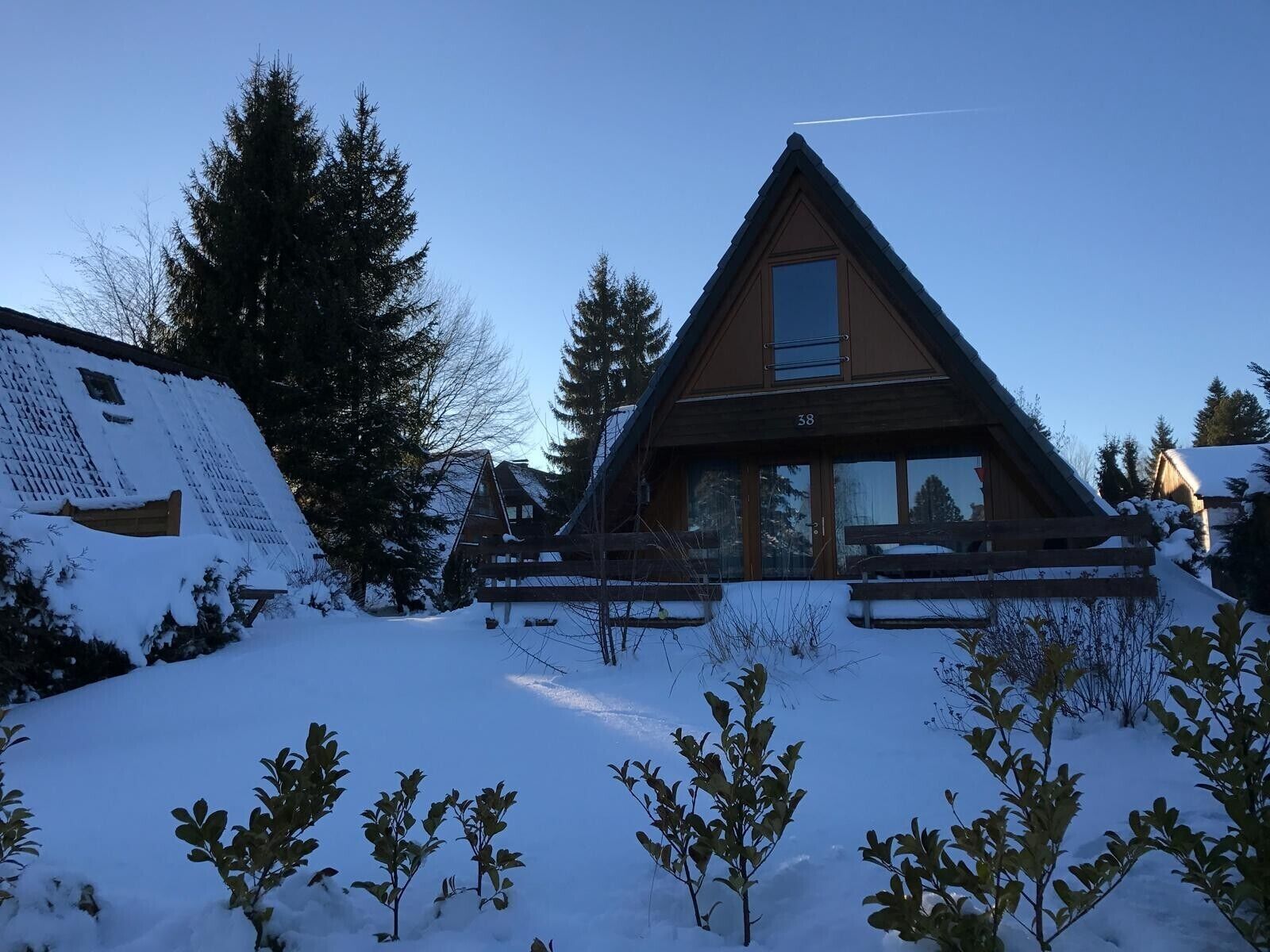 A cabin with a triangular roof, a large window, and a number '38' on the front.