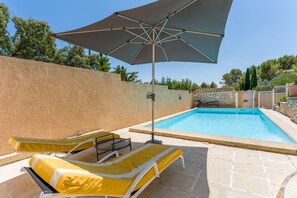 A swimming pool with lounge chairs and a large umbrella. - Villa 'L'Angloise' with Private Pool, Wi-Fi and Air Conditioning (Les Angles)