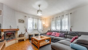 A living room with a fireplace, sofa, and a coffee table. - Villa 'L'Angloise' with Private Pool, Wi-Fi and Air Conditioning (Les Angles)