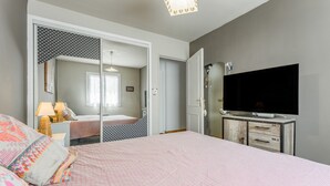 A bedroom with a bed, a TV, a wardrobe, and a mirror. - Villa 'L'Angloise' with Private Pool, Wi-Fi and Air Conditioning (Les Angles)