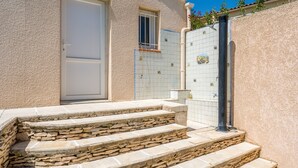 A building with stone steps leading to a door, a window, and a tiled wall. - Villa 'L'Angloise' with Private Pool, Wi-Fi and Air Conditioning (Les Angles)
