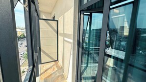 Un pasillo con ventanas amplias, suelo de baldosas y vista panorámica de la ciudad.