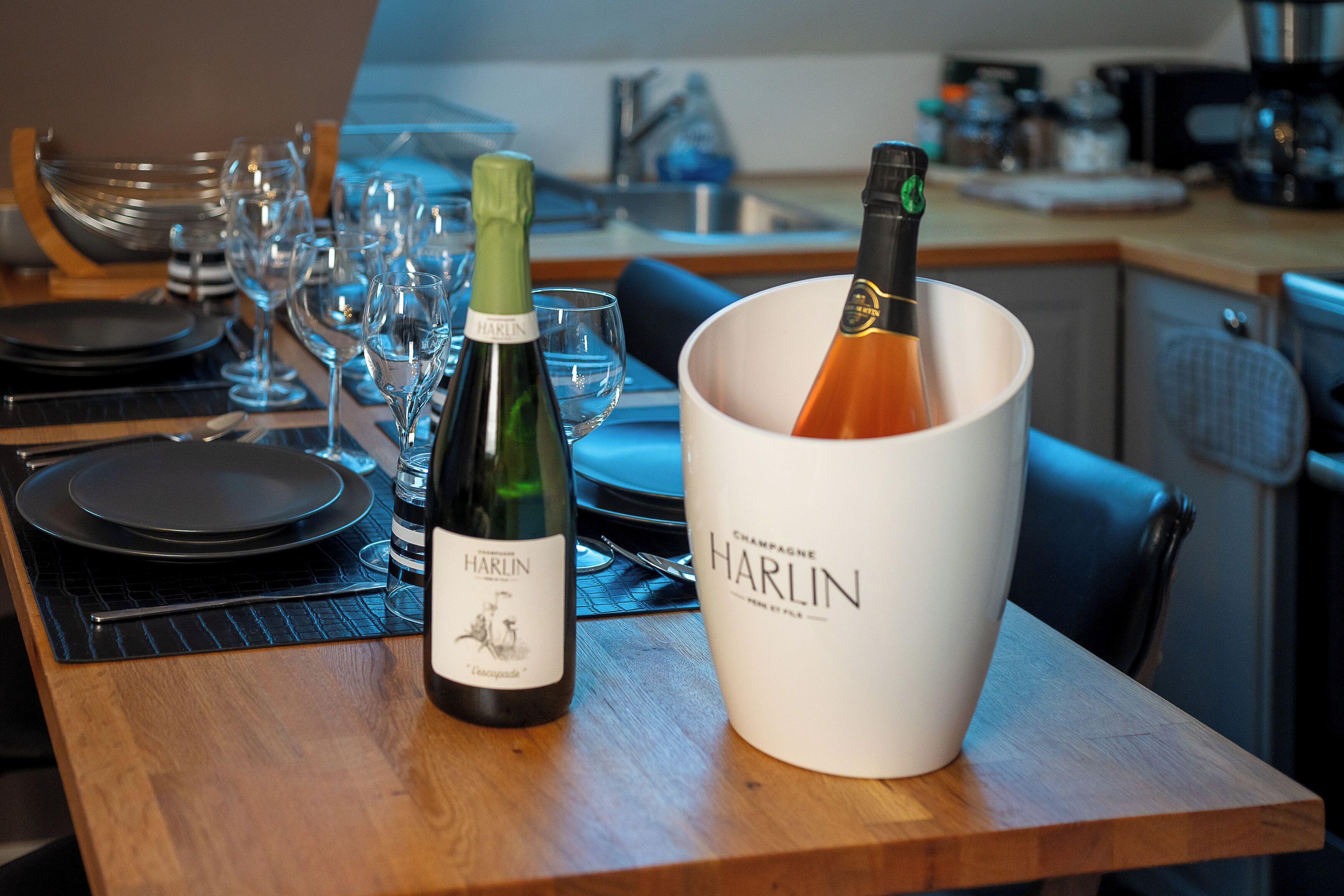 Ein Tisch mit Weingläsern, einer Flasche Harlin Champagner und einem Champagnerkühler.