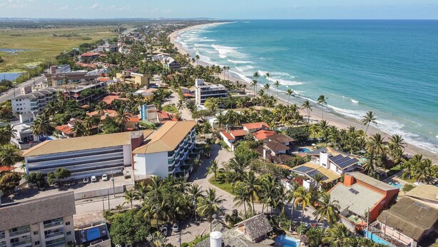 A coastal town with a beach, buildings, and palm trees. - Aquarius Residence (Ipojuca)