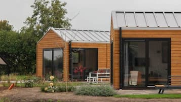 Ein modernes Holzhaus mit großen Fenstern und einem Metalldach.