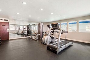 Ein Fitnessstudio mit Laufbändern, Crosstrainern und Gewichtstrainern.