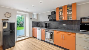 A modern kitchen with a built-in oven, a coffee maker, and a dishwasher. - Room 'Ferienzimmer Nala und Loft' for Families and Holiday Guests (Görlitz)