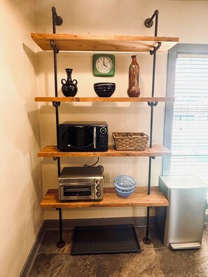 A kitchen with shelves holding a microwave, toaster, and a clock. - Historic Oasis - just blocks from downtown Rockford (Rockford)