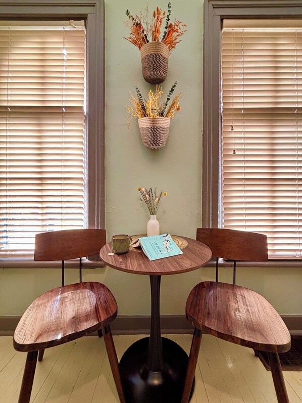 A dining area with a round table, two wooden chairs, a vase with dried plants, and a book titled 'IRIGAI'. - Historic Oasis - just blocks from downtown Rockford (Rockford)
