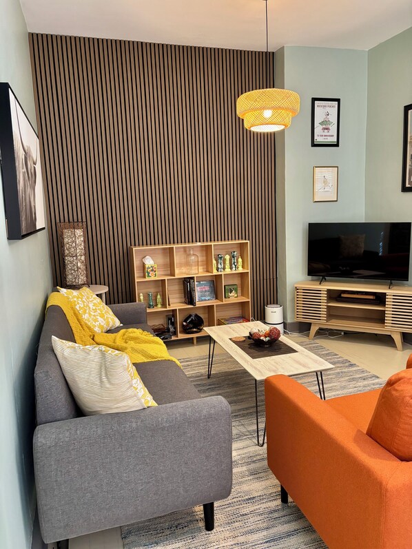 Uma sala de estar moderna com sofá, mesa de centro e aparador para TV.