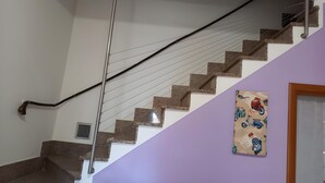 Eine Treppe mit Handlauf, einem Lüftungsgitter und einem an der Wand befestigten Bild von Rollern.