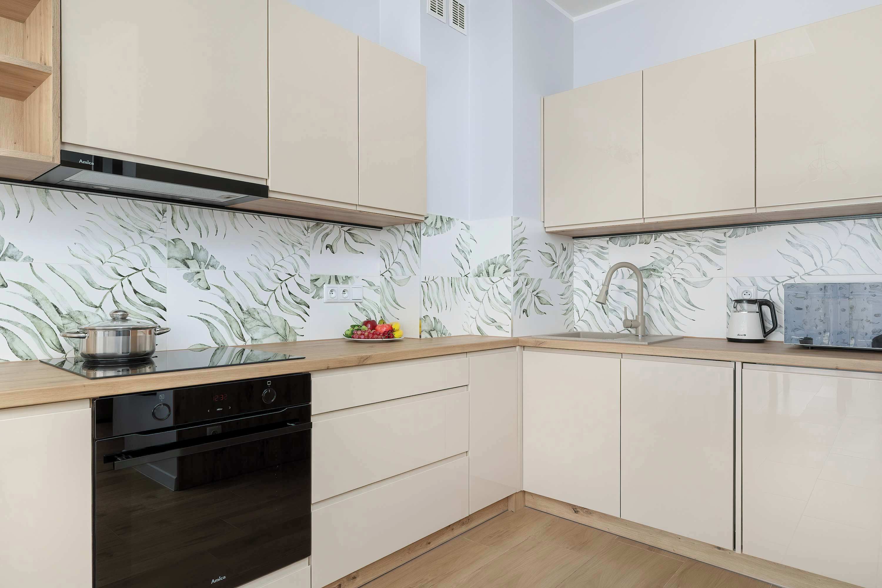 A modern kitchen with a built-in oven, a microwave, and a coffee maker on the countertop.