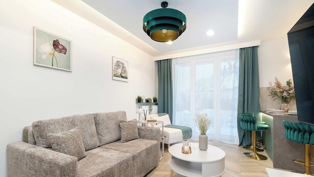 A modern living room with a sofa, a round coffee table, and a bar area with stools.