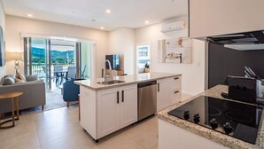 Een moderne keuken met een centraal eiland, een ingebouwde vaatwasser en een zwart inductiekookplaat.