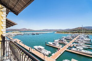 A marina with multiple boats docked, a clear blue sky, and a mountainous landscape in the background. - 308 Adjoining Standard Room Marina View (Playa Flamingo)
