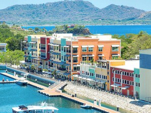 Un hotel frente al agua con edificios de colores, un muelle y barcos.