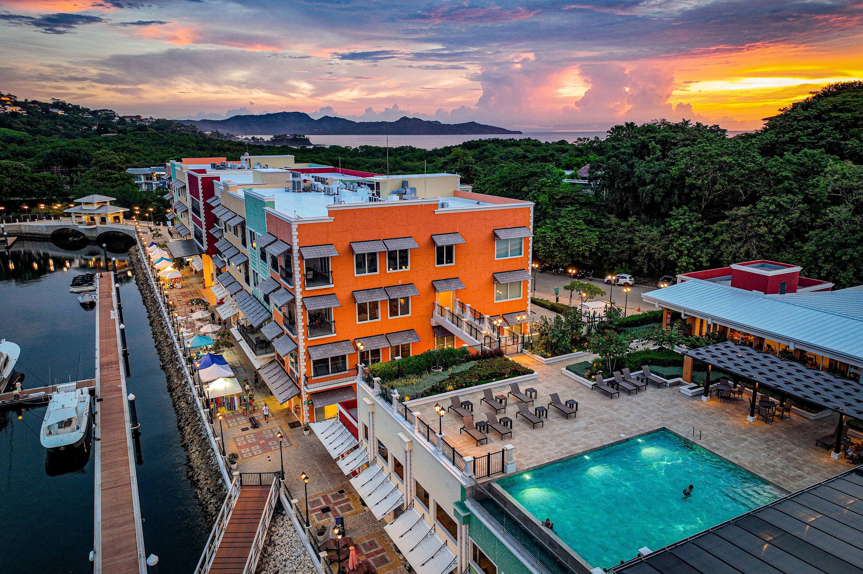 Ein Hotel mit Schwimmbad, Außenbereich und einer Anlegestelle für Boote.
