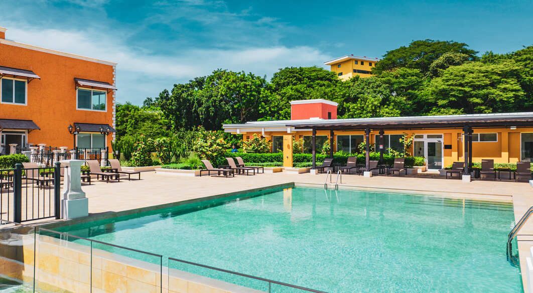 Ein Swimmingpool mit Liegestühlen und einer überdachten Sitzgelegenheit.