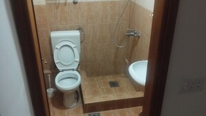 Pieni kylpyhuone, jossa on wc, bidee ja suihku.