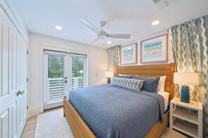 A bedroom with a bed, a ceiling fan, a nightstand, a lamp, and a window with blinds. - NEW! Gulfbreeze Guest Cottage, 151 Steps to Seaside Beach Access (Santa Rosa Beach)