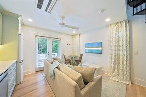 Ein Wohnzimmer mit einer Couch, Sesseln, einem Tisch und einem Bild an der Wand.