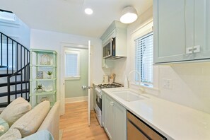A kitchen with a stove, sink, and cabinets. - NEW! Gulfbreeze Guest Cottage, 151 Steps to Seaside Beach Access (Santa Rosa Beach)