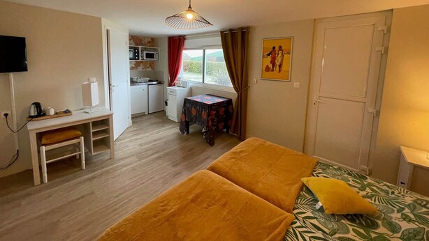 Habitació senzilla amb llit, escriptori, petita cuina i finestra.