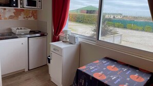 Cuina compacte amb microones, nevera petita i un rentaplat. Hi ha una finestra amb vista a l'exterior.