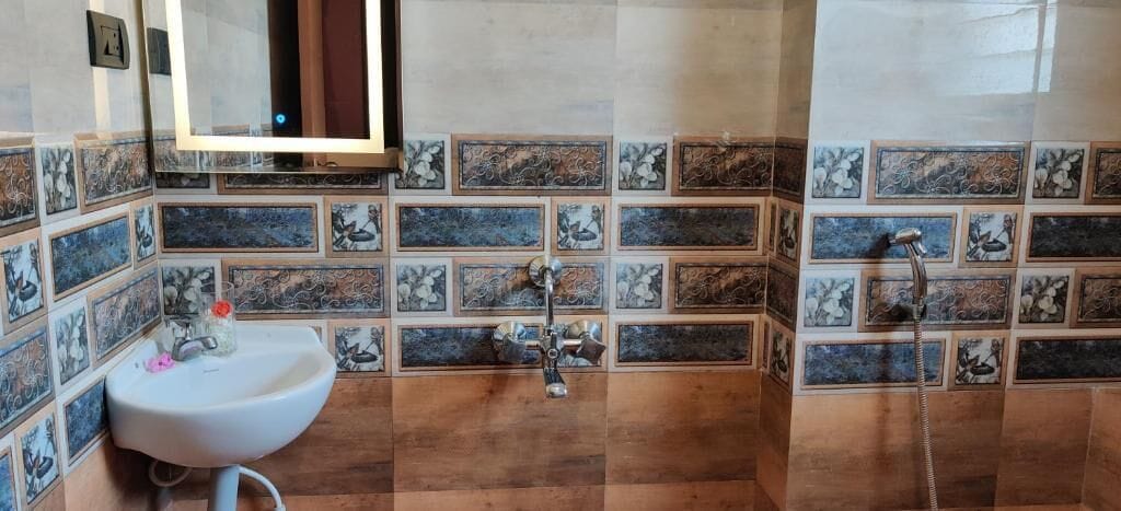 A bathroom with a sink, mirror, and shower.