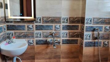A bathroom with a sink, mirror, and shower.