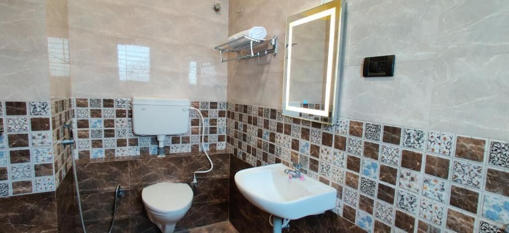 Un baño con inodoro, lavabo y paredes de azulejos.