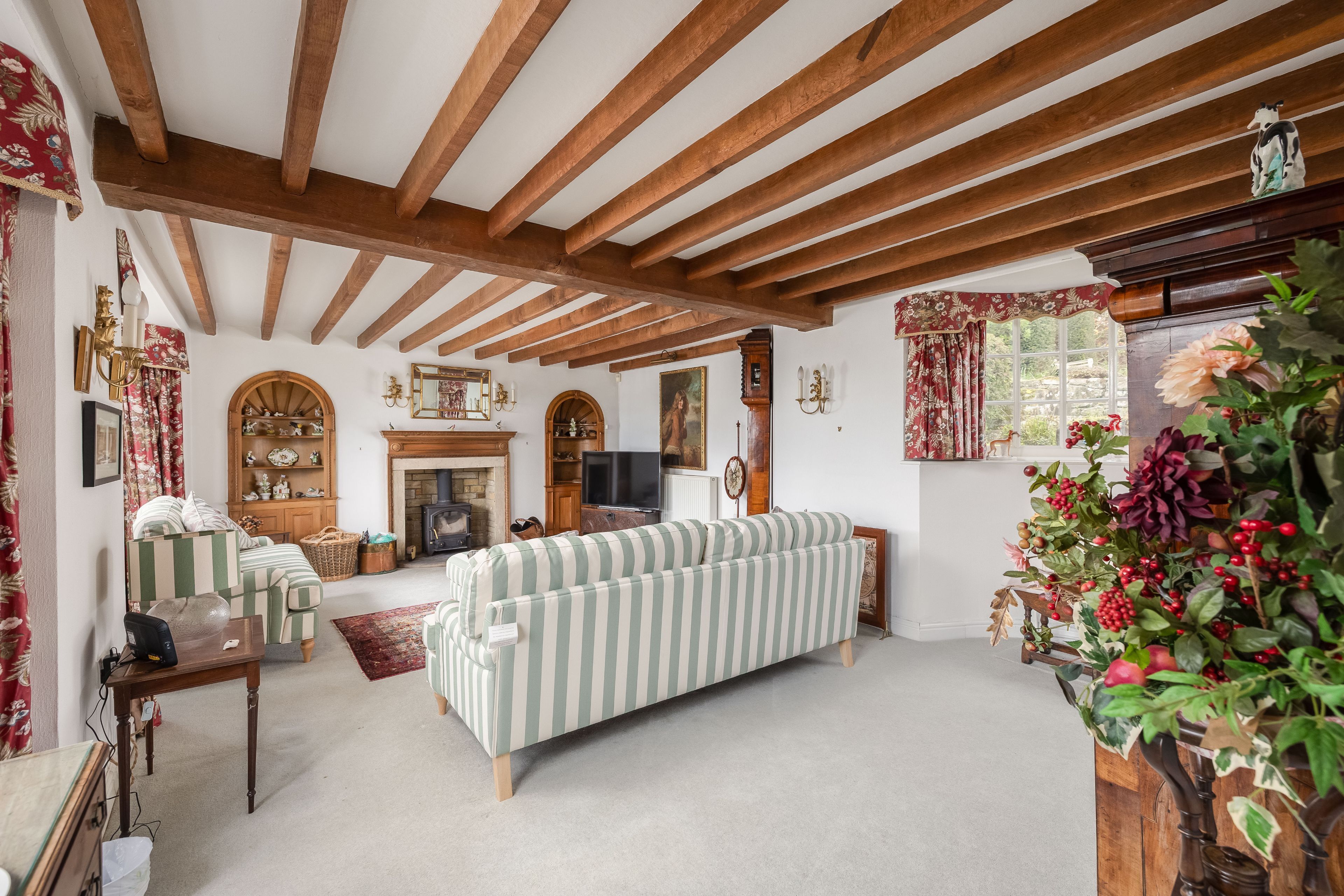 Ein gemütliches Wohnzimmer mit einer Couch, einem Kamin und Holzbalken an der Decke.