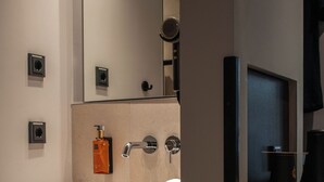 A bathroom with a sink, mirror, towel, and a trash can. - gambino hotel GOETHE26 (Munich)